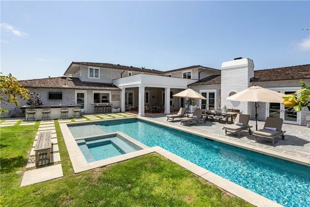 a view of a house with swimming pool and chairs