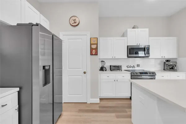 a kitchen with stainless steel appliances granite countertop a sink stove refrigerator and cabinets