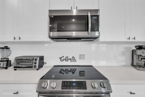 a kitchen with stainless steel appliances a refrigerator sink and white cabinets