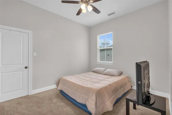 a bedroom with a bed next to a window