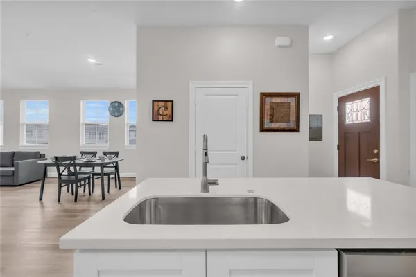 a view of kitchen with sink refrigerator and cabinets