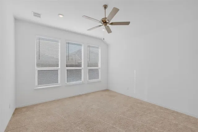 an empty room with a window and a fan