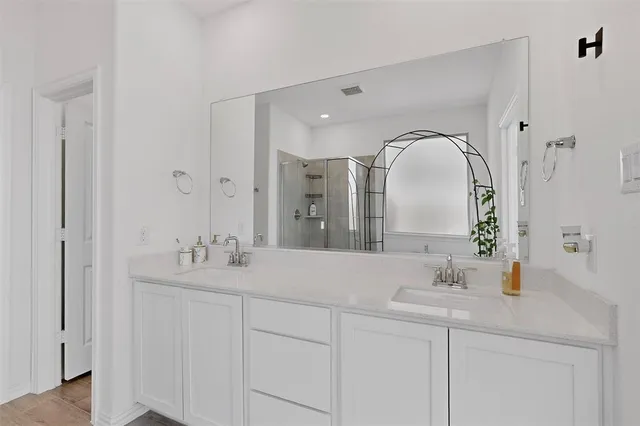 a bathroom with a double vanity sink and mirror