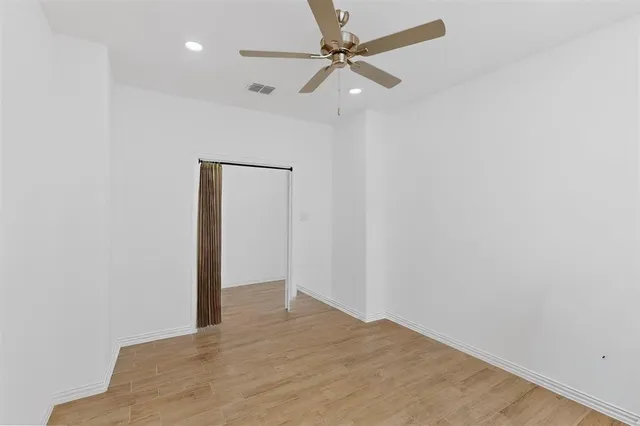 an empty room with a ceiling fan and a window