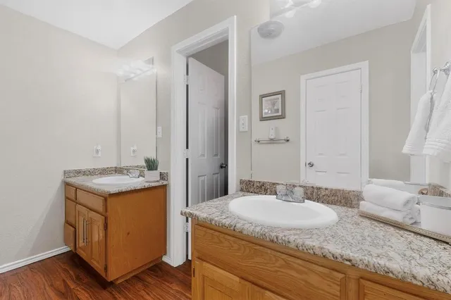 a bathroom with a granite countertop sink a mirror and a toilet