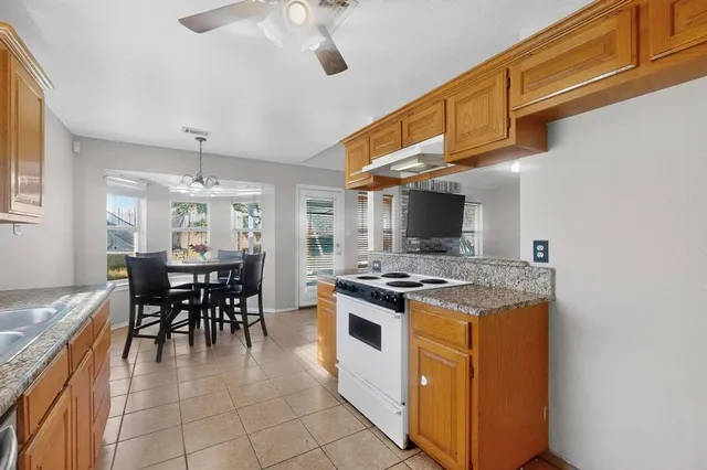 a kitchen with a stove and chairs
