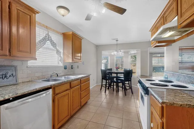 a kitchen with stainless steel appliances granite countertop sink stove top oven and cabinets