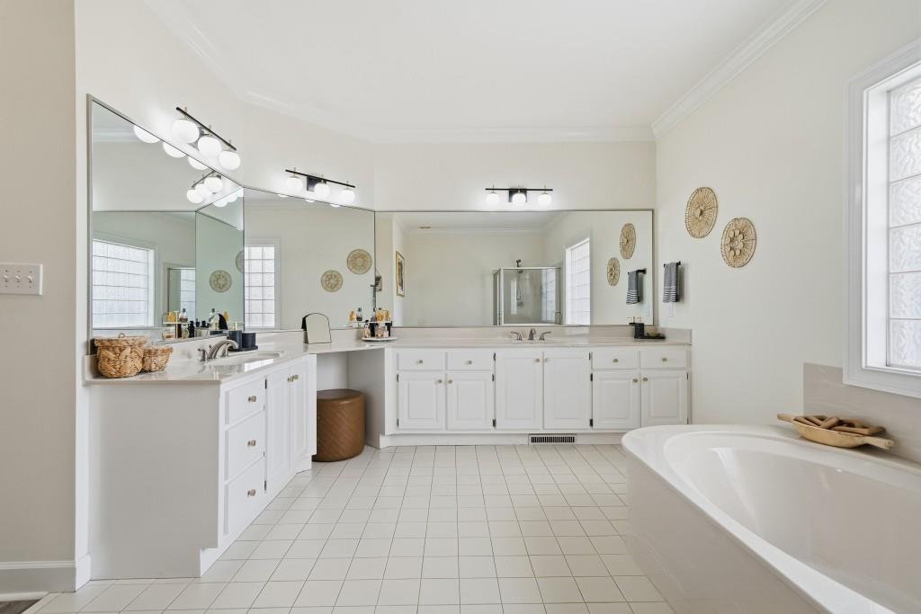 398 South 6th St Extension Milner, GA 30257 - Photo 11 of 30 a large white bathroom with a large mirror vanity sink and bathtub