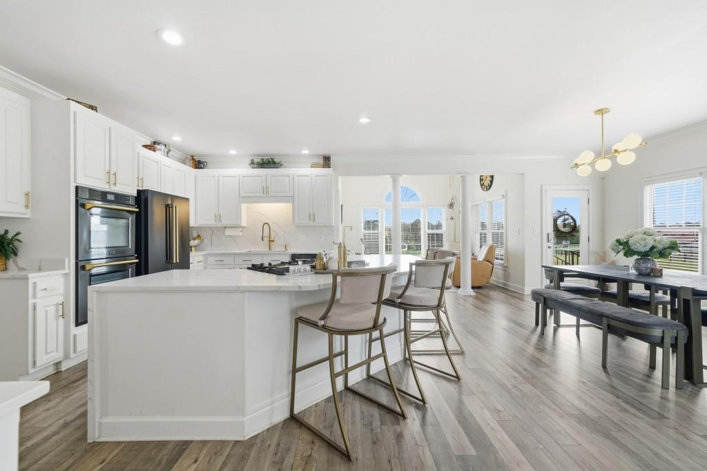 398 South 6th St Extension Milner, GA 30257 - Photo 6 of 30 a kitchen with stainless steel appliances a dining table chairs stove refrigerator and cabinets