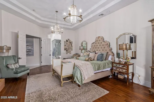 a bedroom with a bed a chandelier and closet