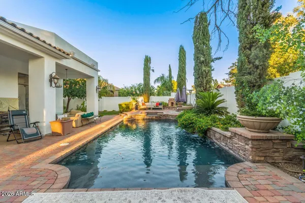 a view of a patio with couches table and chairs with wooden fence and plants