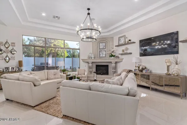 a living room with furniture a fireplace and a chandelier