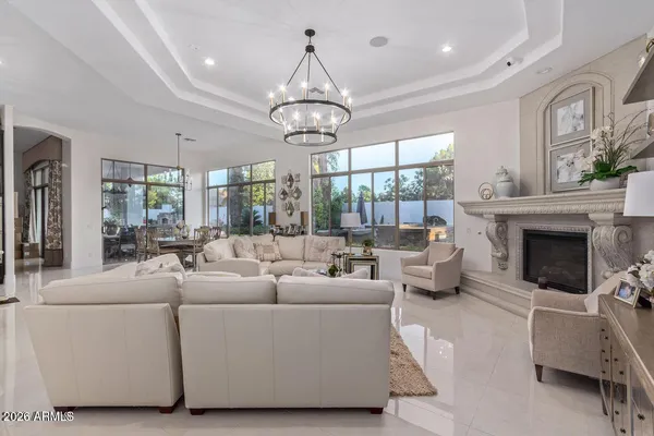 a living room with furniture a chandelier and a large window