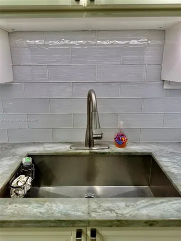 a kitchen with sink and chairs