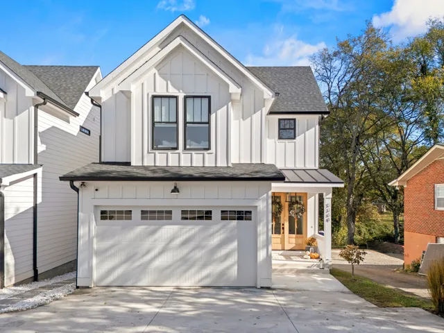 a view of a dining room and livingroom with furniture a rug a fireplace and a chandelier