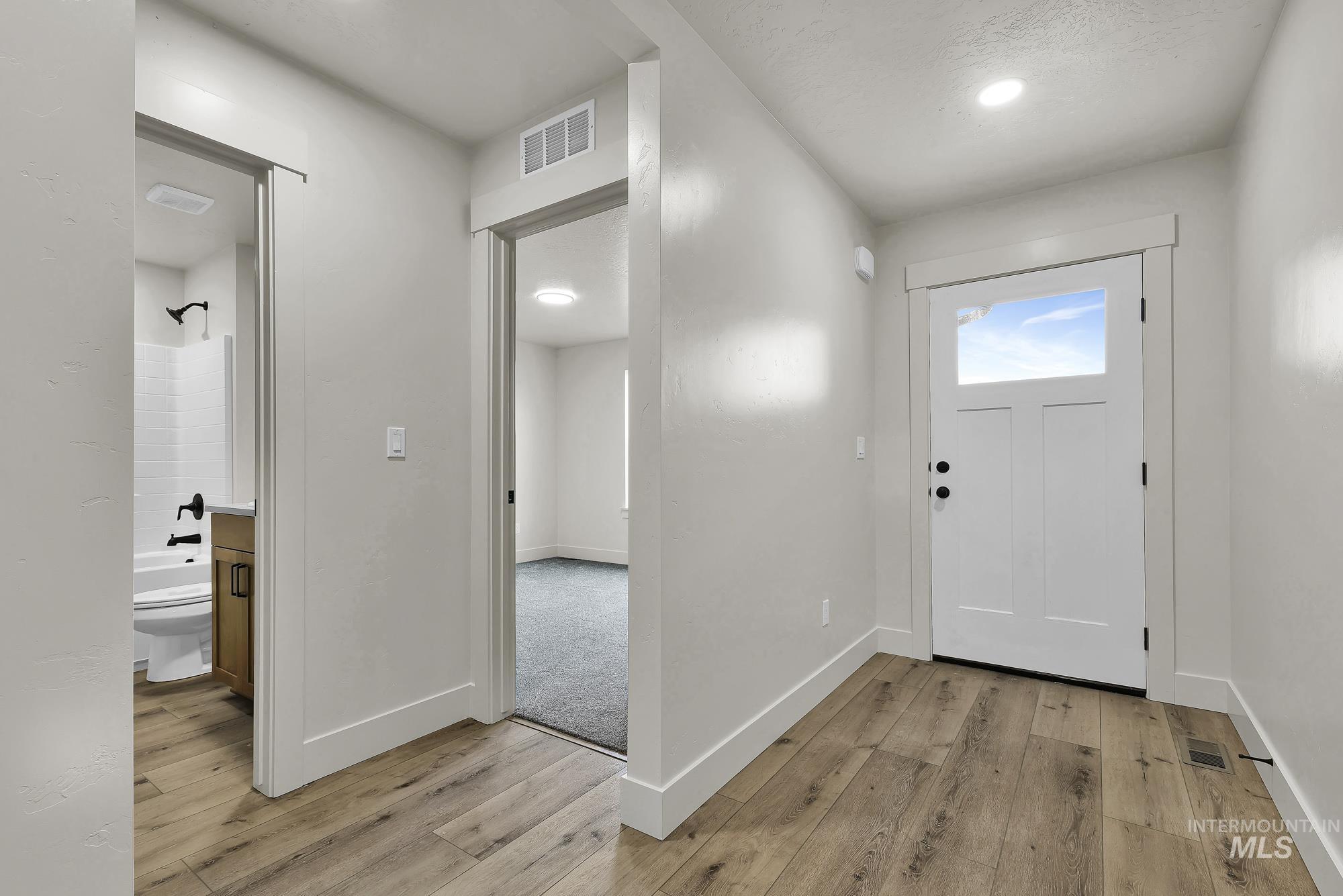 1130 Velvet Loop Wilder, ID 83676 - Photo 27 of 35 Entryway featuring wood-finish flooring, a white paneled door with a transom window, and recessed lighting