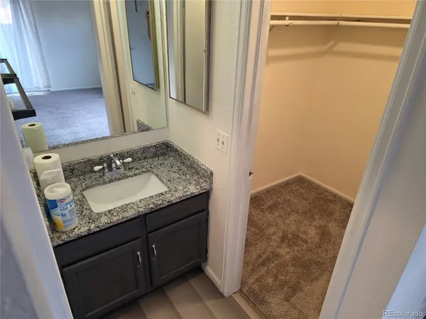 a bathroom with a granite countertop sink and a mirror