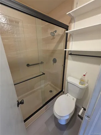 a bathroom with a toilet and a shower