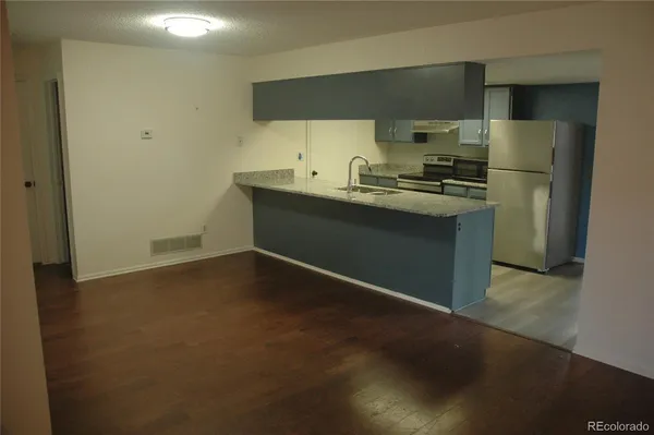 a kitchen with granite countertop a refrigerator and a sink