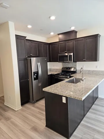 a kitchen with stainless steel appliances granite countertop a sink refrigerator and microwave