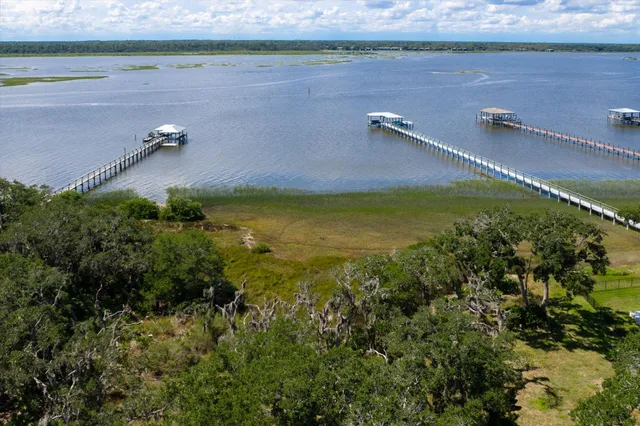 a view of a water pond with green field