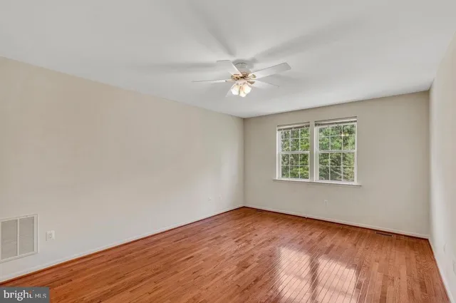 an empty room with a window and a ceiling fan