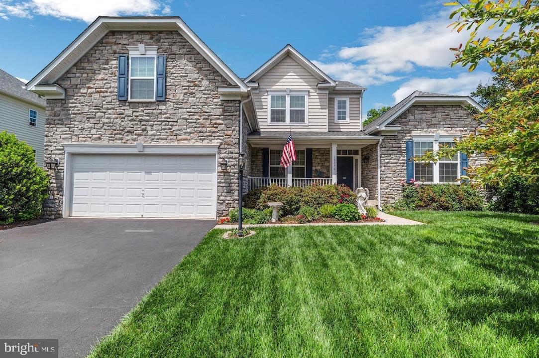 18776 Pier Trail Drive Triangle, VA 22172 - Photo 2 of 32 a front view of a house with a yard and garage