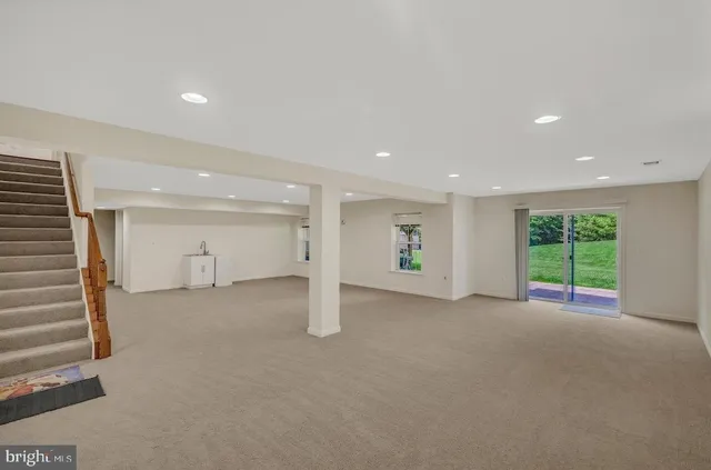 a view of an empty room with a window and a kitchen