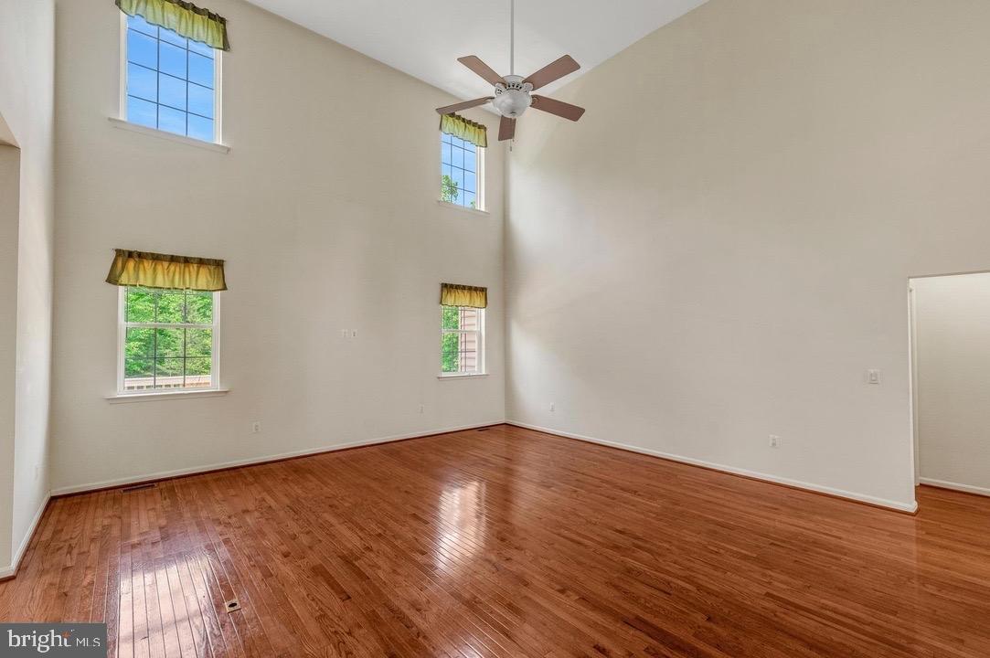 18776 Pier Trail Drive Triangle, VA 22172 - Photo 7 of 32 an empty room with wooden floor chandelier fan and windows