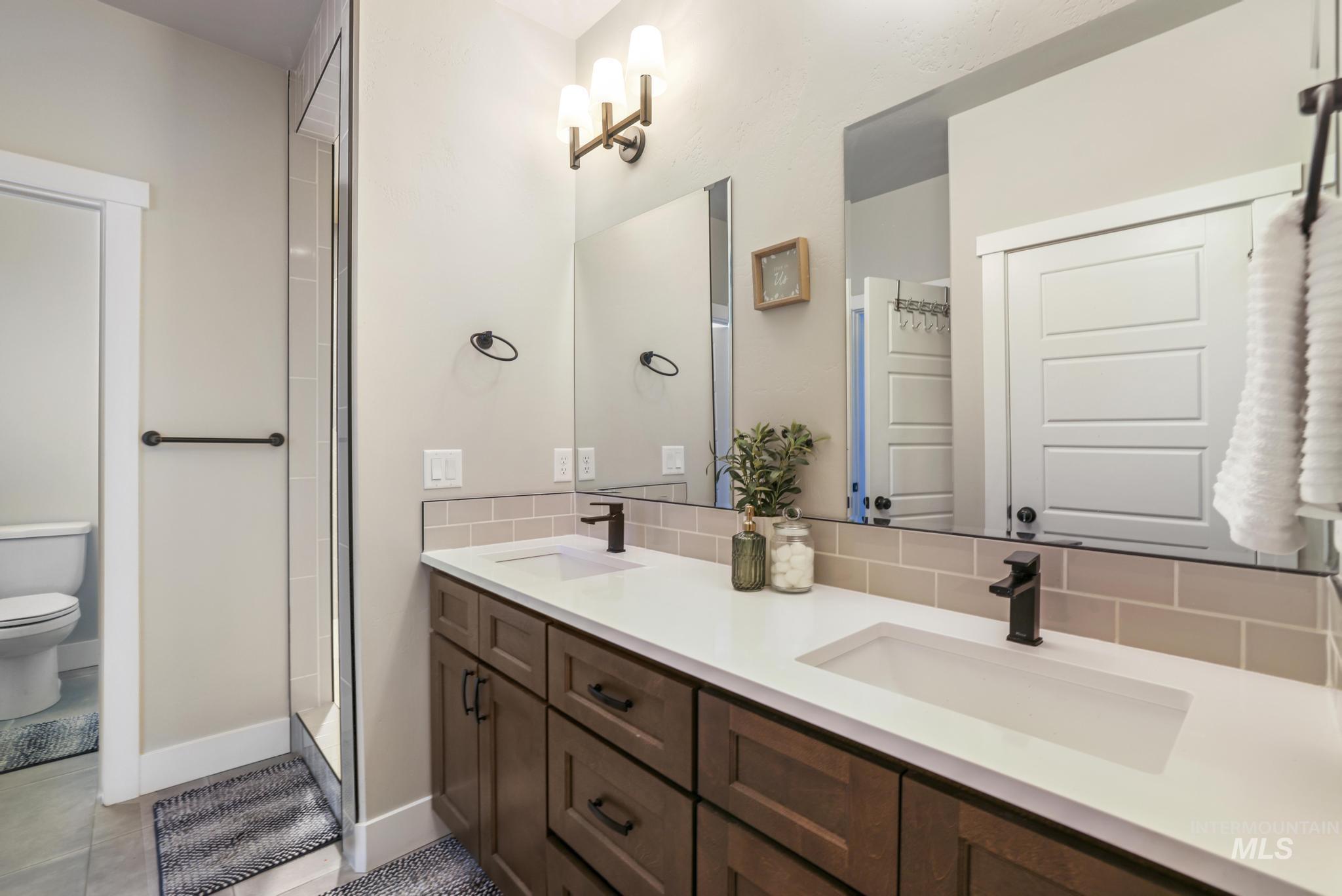 3103 Moonrise Road Twin Falls, ID 83301 - Photo 18 of 42 Bathroom with double vanity, walk in shower, and decorative backsplash