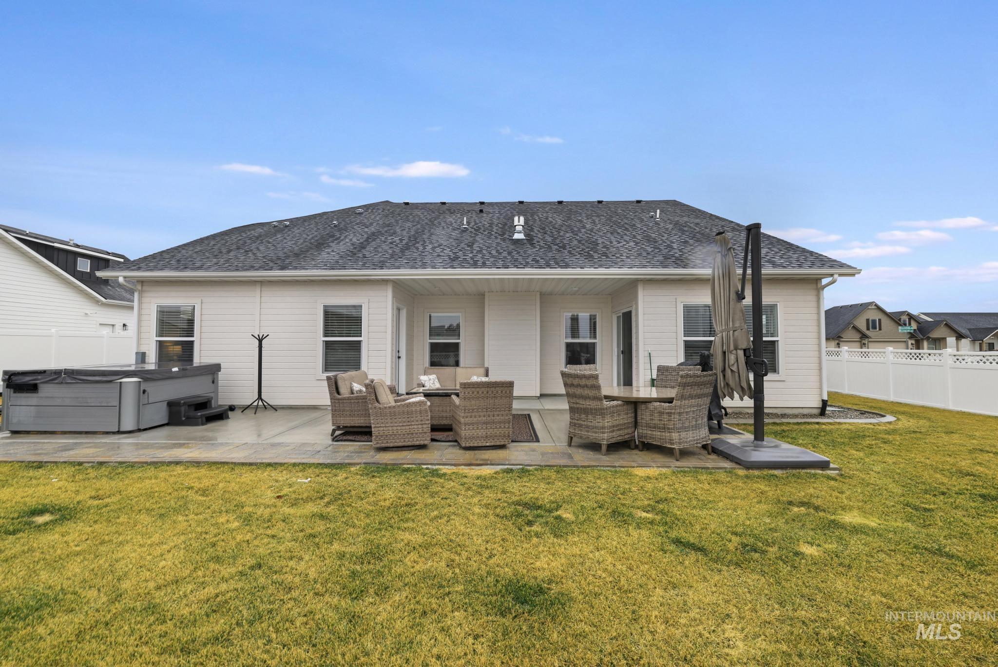 3103 Moonrise Road Twin Falls, ID 83301 - Photo 34 of 42 Rear view of house with a hot tub, an outdoor living space, a patio, and roof with shingles
