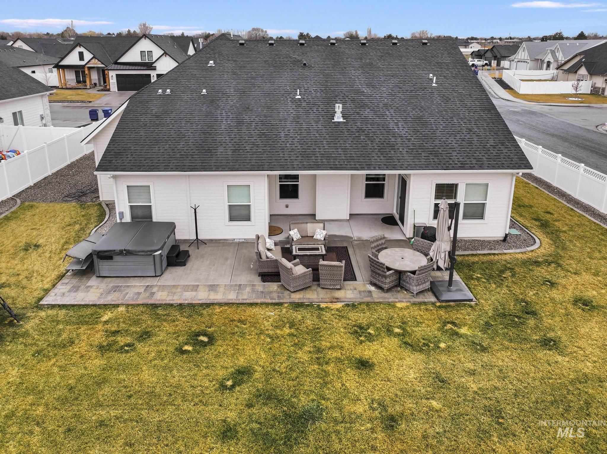 3103 Moonrise Road Twin Falls, ID 83301 - Photo 37 of 42 Rear view of property featuring an outdoor hangout area, a residential view, a fenced backyard, a patio, and a hot tub