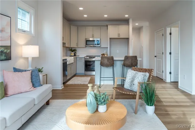 a living room with furniture potted plant and kitchen view