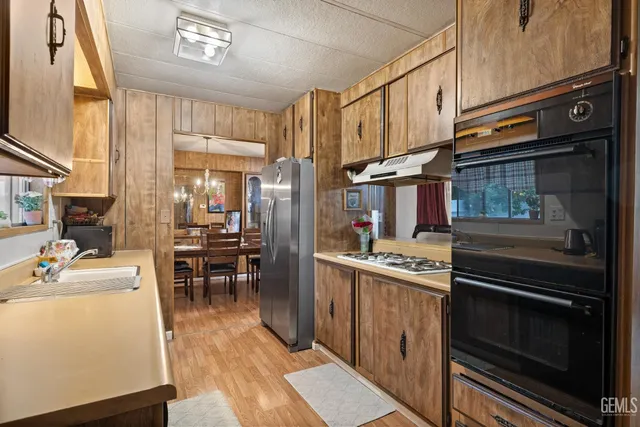 a kitchen with stainless steel appliances granite countertop a stove refrigerator and cabinets
