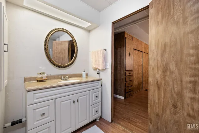 a bathroom with a granite countertop sink vanity mirror and a