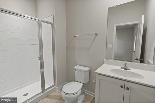 a bathroom with a shower sink vanity mirror and toilet
