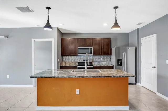 a view of an empty room with closet and a window