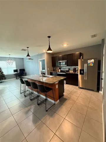 a kitchen with stainless steel appliances granite countertop a sink a stove and a refrigerator