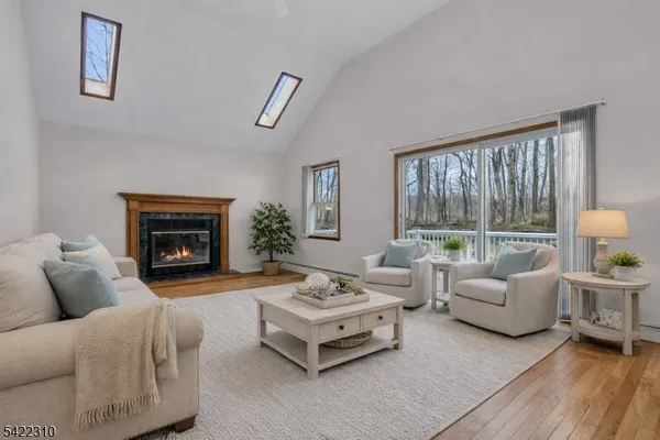 a view of an empty room with wooden floor and a fireplace