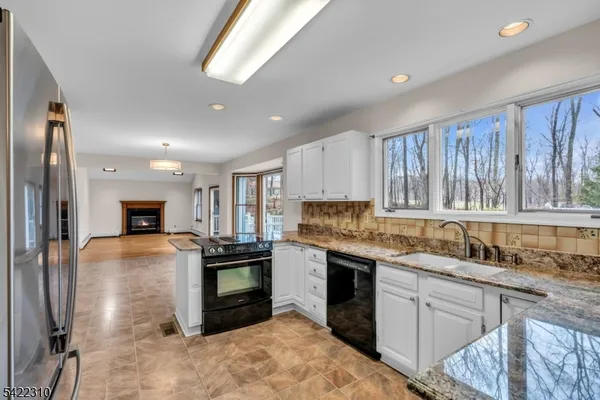 a kitchen with stainless steel appliances granite countertop a refrigerator sink and stove
