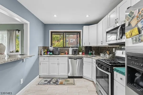 a kitchen with stainless steel appliances granite countertop a stove a sink and a microwave