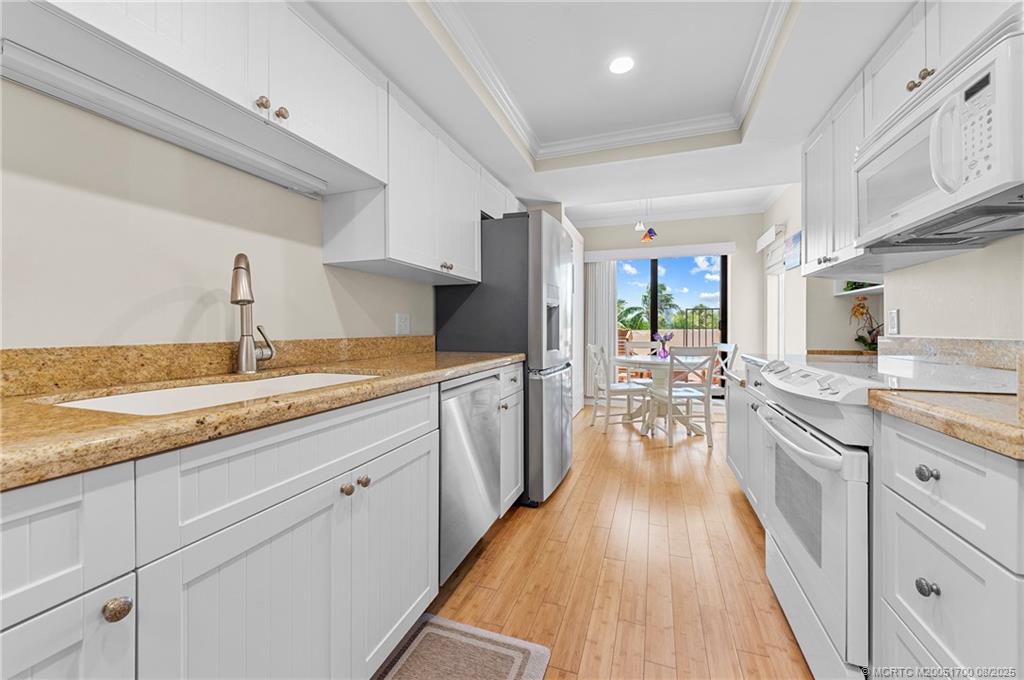 4651 Northeast Ocean Boulevard, Unit B26 Stuart, FL 34996 - Photo 17 of 35 a kitchen with sink cabinets and wooden floor