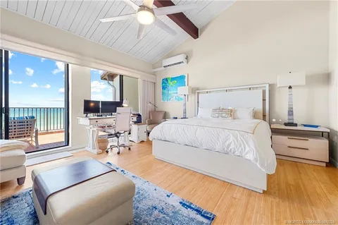 a bedroom with a bed couch and a large window