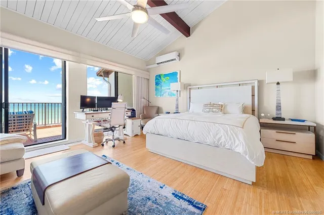 a bedroom with a bed couch and a large window