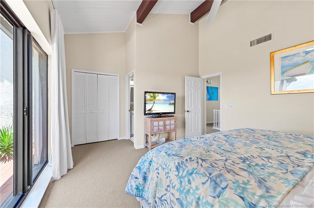 4651 Northeast Ocean Boulevard, Unit B26 Stuart, FL 34996 - Photo 33 of 35 a bedroom with a bed and a flat screen tv