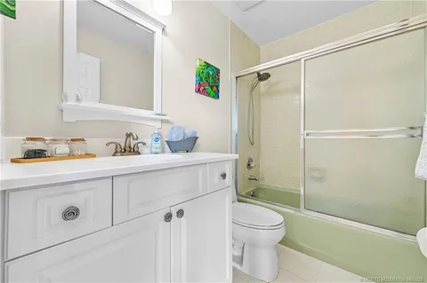 a bathroom with a shower sink vanity mirror and toilet