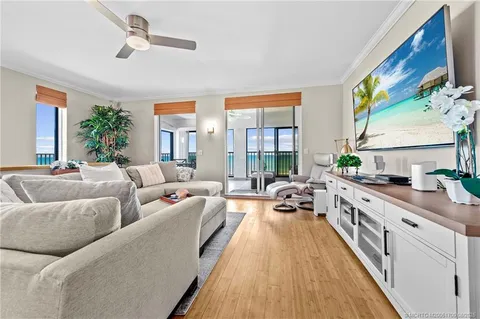 a living room with furniture wooden floor and a chandelier
