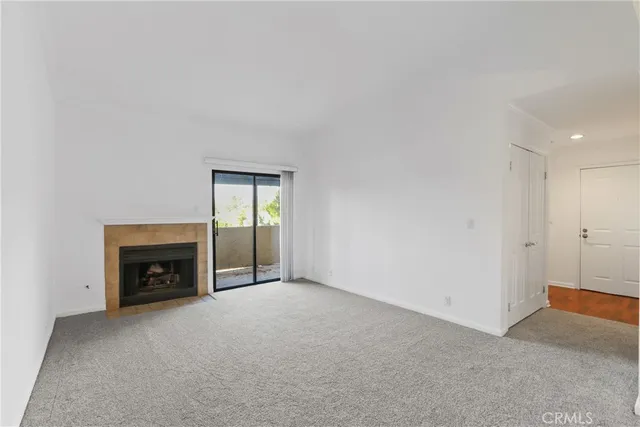 a view of an empty room with a fireplace and a window
