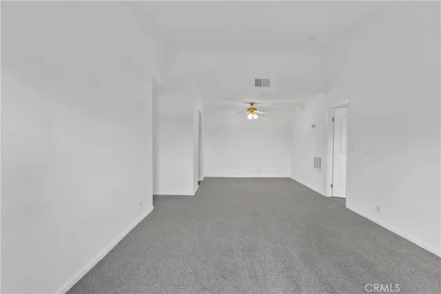an empty room with closet and a ceiling fan
