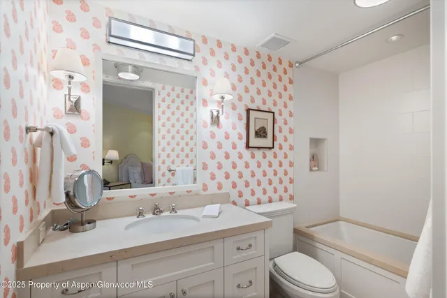 a bathroom with a granite countertop sink toilet mirror and shower